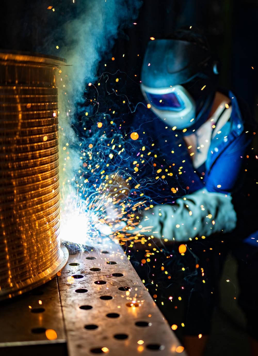 Schweissarbeit mit sprühenden Funken an einem Werkstück in der Werkstatt